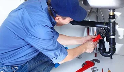 Profesjonalny hydraulik z narzędziami naprawia instalacje sanitarne, oferując szybkie i niezawodne usługi hydrauliczne.