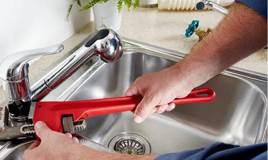 Profesjonalny hydraulik z narzędziami naprawia instalacje sanitarne, oferując szybkie i niezawodne usługi hydrauliczne.