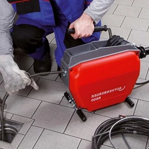 Profesjonalny hydraulik z narzędziami naprawia instalacje sanitarne, oferując szybkie i niezawodne usługi hydrauliczne.