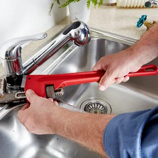 Profesjonalny hydraulik z narzędziami naprawia instalacje sanitarne, oferując szybkie i niezawodne usługi hydrauliczne.